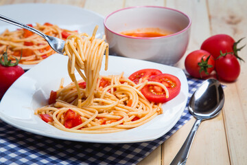 Spaghetti pasta with and tomato sauce on wood background