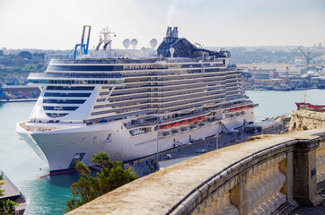 Mega modern MSC cruiseship or cruise ship liner in port of Valletta, Malta island with panoramic...