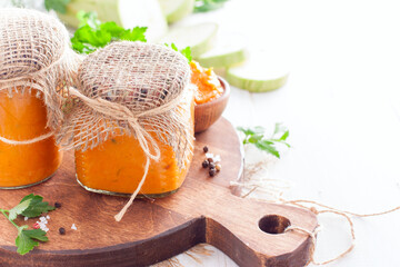 Homemade squash caviar in glass jars for storage on a wooden board, horizontal, copy space