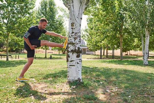 Man stretching after exercise in a park.