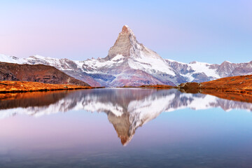 Picturesque landscape with colorful sunrise on Stellisee lake. Snowy Matterhorn Cervino peak with...