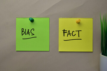 Bias and Fact write on sticky notes isolated on office desk.