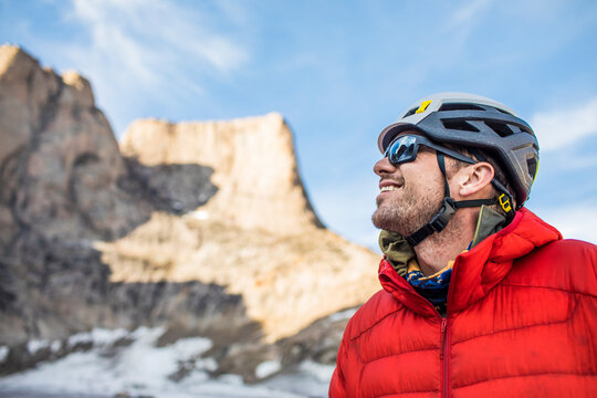 Smiling side view portrait of mountain climber below summit.