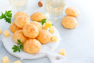 Baked cheese balls on white board with glasses of white wine, horizontal, copy space