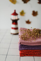 Stack of colourful linen towels or pile of textile napkins on kitchen table. Fall home decoration. Autumn cozy mood still life