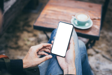 cell phone mockup blank white screen.woman hand holding texting using mobile on desk at coffee shop.background empty space for advertise.work people contact marketing business,technology