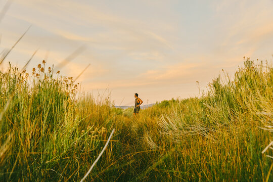 Young man far away in tall grass near Mono Lake in northern California