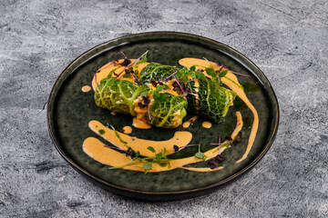 Cabbage rolls in a salad leaf with herbs and sauce