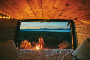 Young man by campfire in Mono Lake at night in northern California.