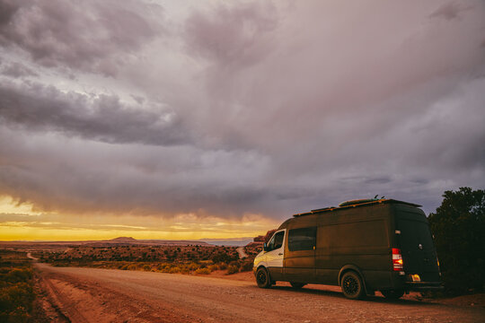 Camper van off side of dirt road during golden sunset in Moab, Utah.