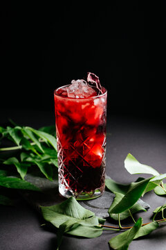 glass of alcoholic coctail with ice on black background