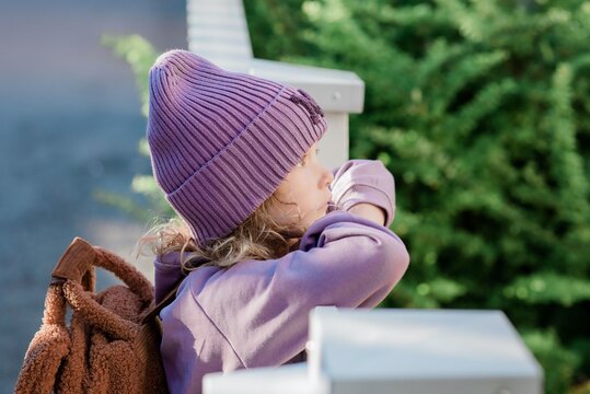 portrait of a young girl leaning on a gate thinking about School