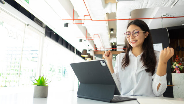 Portrait of cheerful female office worker celebrating while working in office