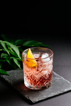 glass of alcoholic coctail with ice on black background