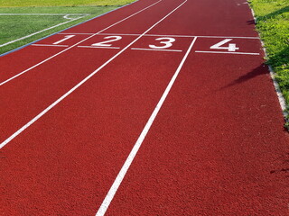 Red running racetrack on the stadium. Red running tracks in the stadium. Empty sport stadium. Starting Line of Track Running Lanes in  stadium