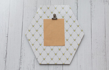 blank piece of papaer on octagon shaped note board white wooden background.  Bee  pattern note...