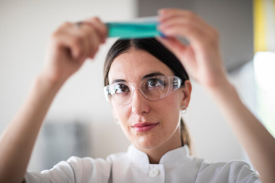 scientist female with lab glasses, tablet and sample in a lab