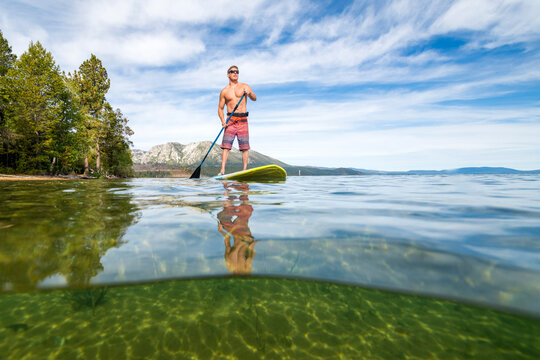 A man stand up paddle boarding on Lake Tahoe, CA