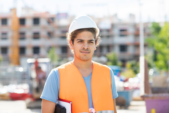 young construction engineer with helmet working outside