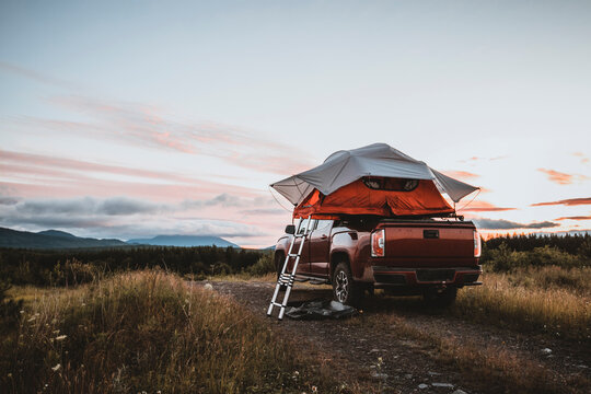 Roof top tent on pick up truck in remote campsite in woods of maine