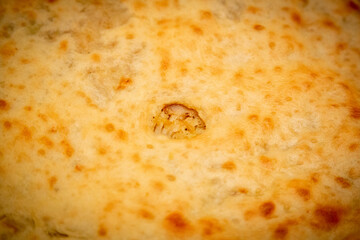 Freshly cooked delicious closed pie with hot cheese inside