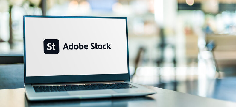Laptop computer displaying logo of Adobe Stock
