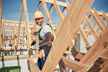 Naklejka na ściany i meble Construction worker wearing a helmet and holding a drill