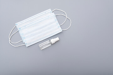 Surgical mask, medical mask and alcohol antibacterial antiseptic hand gel on gray background, concept picture