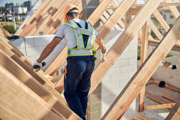 Cautious contractor working on a roof of a constructed building