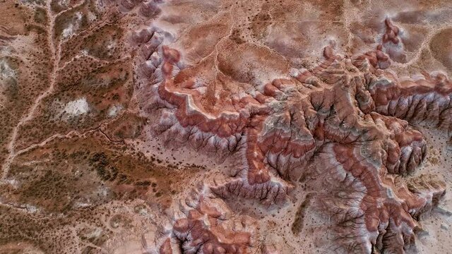 Flying over dry desert of the Red Hills in Wyoming moving through the sky viewing the patters from erosion in the dirt.