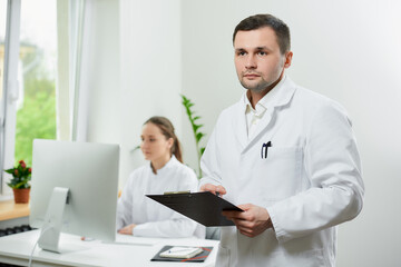 A surgeon with bristles in a white coat holds a clipboard analyzing documents
