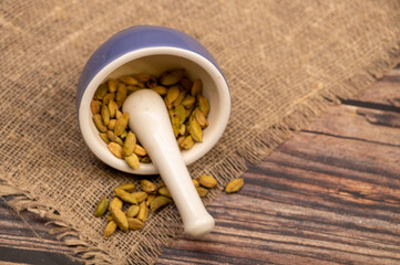 Cardamom in a ceramic mortar and pestle, close-up, selective focus.