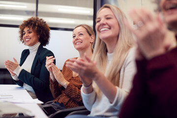 Line Of Businesswomen In Modern Office Applauding Presentation By Colleague