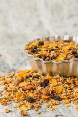 oatmeal or granola with almonds and hazelnut for nutritious breakfast on white marble background