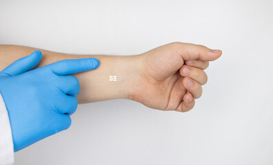 The cosmetic surgeon shows the patient's hand with a biological chip. The concept of cybernetics, biotechnology and high-tech future. Isolated on white