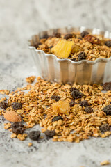 oatmeal or granola with almonds and hazelnut for nutritious breakfast on white marble background