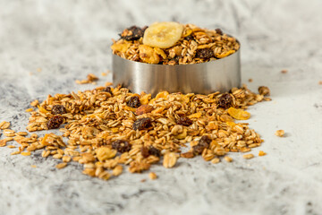oatmeal or granola with almonds and hazelnut for nutritious breakfast on white marble background
