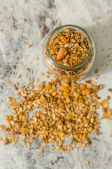 oatmeal or granola with almonds and hazelnut for nutritious breakfast on white marble background