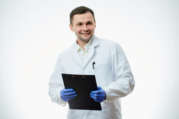 A happy male caucasian doctor in a white lab coat and blue disposable medical gloves is waiting with a patient card with a diagnosis. A scientist is isolated over white background.