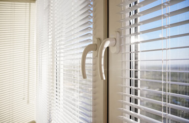 Metal plastic windows with blinds close up view on handle