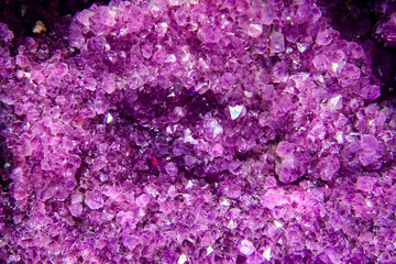Large geode of amethyst crystals. Purple palette. Soft selective focus.