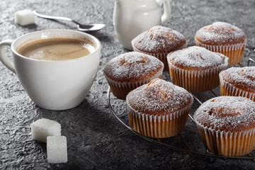 Coffee muffins on a wooden Board. Sweet muffins with berry filling on the table.Muffins sprinkled with powdered sugar.