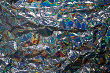 Glued colorful holographic background. Modern Rainbow foil for Texture, cover, wallpaper, print, dll. Dark futuristic blurred hologram and Abstract gradient colors.