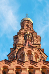 Old brick bell tower of the Orthodox Church against the blue sky