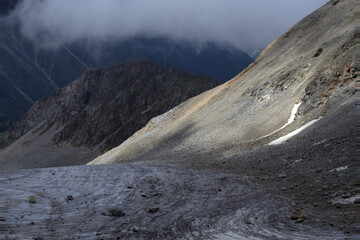 View of the glacier from the mountain pass. View from the Koshtan pass (3513 meters above sea level). Caucasus, Russia.