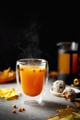 hot autumn sea-buckthorn drink on a dark background