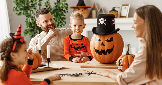 Happy family decorates the house, getting ready for the Halloween celebration.