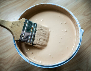Paint brush and color in a paint bucket.