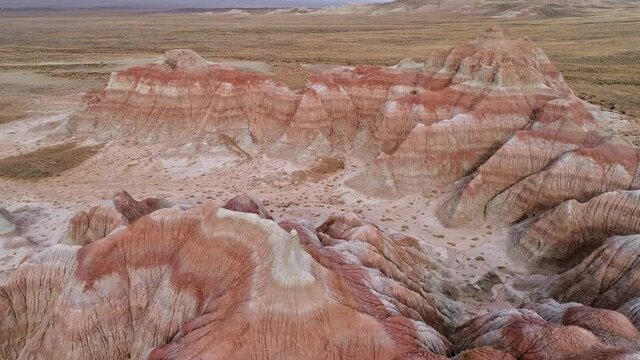 Flying over striped red desert hills in Wyoming viewing the texture and patters from erosion.