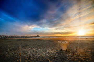 Trash bin on the sand in Newport Beach at sunset